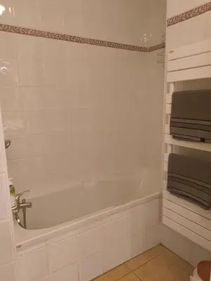 a white bathroom with a tub and towels at Appartement idéal séjour touristique et pro in Vedène