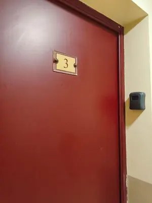 a red door with the number three on it at Appartement idéal séjour touristique et pro in Vedène