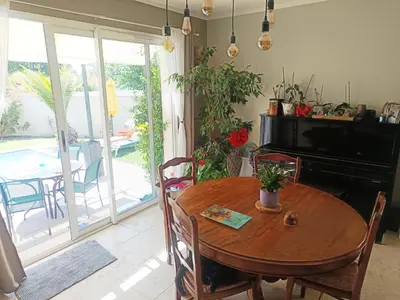 a dining room with a wooden table and a piano at Villa KAMARO in LʼIsle-sur-la-Sorgue