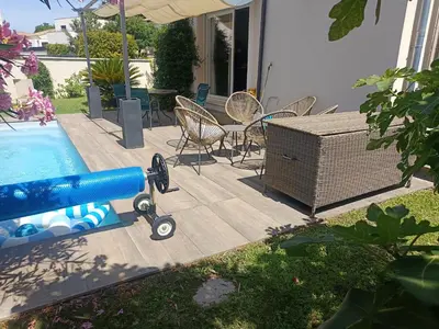 a swimming pool with chairs and a table and a blue hose at Villa KAMARO in LʼIsle-sur-la-Sorgue