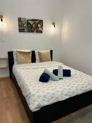 a large bed with two blue pillows on it at T2 centre-ville avec parking privé inclus in Cavaillon
