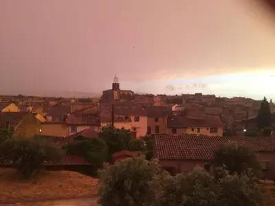 a view of a city with a rainbow in the sky at La Rivayne in Lourmarin