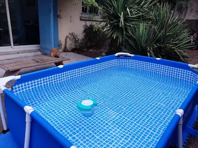 a blue tiled swimming pool in a yard at Two-bedroom apartment with swimming pool for kids in Aix-en-Provence