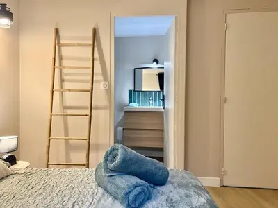a bedroom with a ladder and a bed with blue towels at Le Péli - Cosy, Centre-ville, CLIM, 2 personnes in Pélissanne