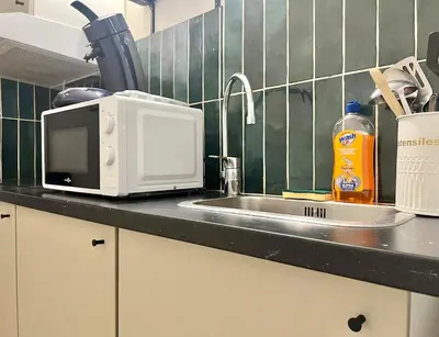 a kitchen counter with a microwave and a sink at Le Péli - Cosy, Centre-ville, CLIM, 2 personnes in Pélissanne