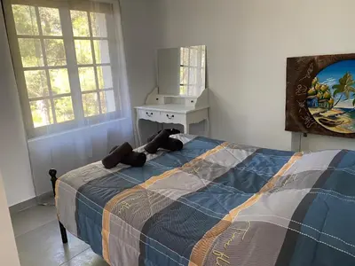 a bedroom with a bed and a desk and windows at Appartement T2 dans le Luberon in Cavaillon