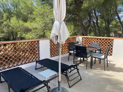 an umbrella and tables and chairs on a patio at Appartement T2 dans le Luberon in Cavaillon