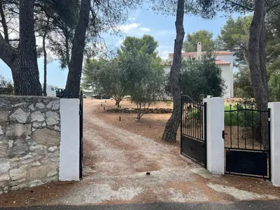 an entrance to a driveway with a gate and trees at Appartement T2 dans le Luberon in Cavaillon