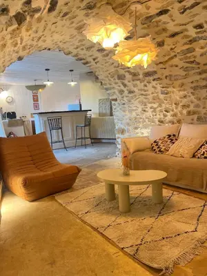 a living room with a couch and a table at Authentique et paisible maison de village in Bédoin