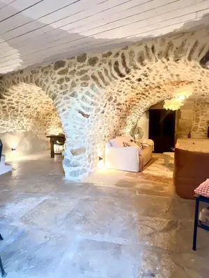 a stone room with a bed in a stone wall at Authentique et paisible maison de village in Bédoin