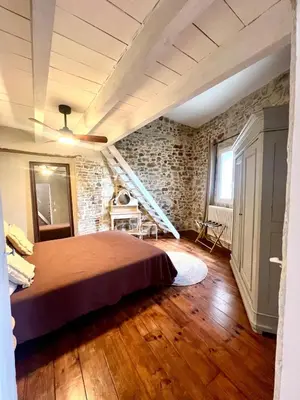 a bedroom with a bed and a brick wall at Authentique et paisible maison de village in Bédoin