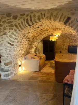a room with a bed in a stone wall at Authentique et paisible maison de village in Bédoin