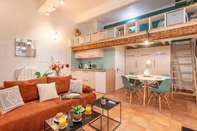 a living room with a couch and a table at Studio Mezzanine Cosy in Aix-en-Provence