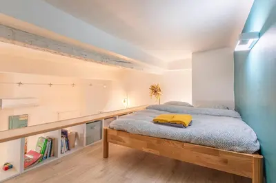a bedroom with a large bed with a wooden frame at Studio Mezzanine Cosy in Aix-en-Provence