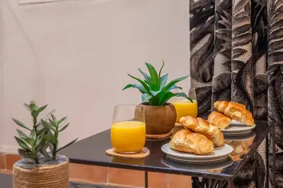 a table with two glasses of orange juice and croissants at Studio Mezzanine Cosy in Aix-en-Provence