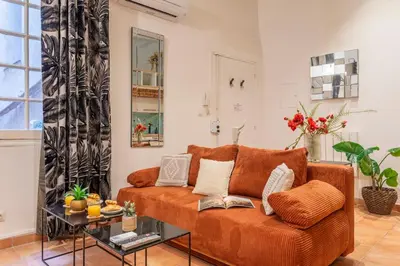 a living room with a couch and a table at Studio Mezzanine Cosy in Aix-en-Provence