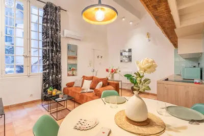 a living room with a table and a couch at Studio Mezzanine Cosy in Aix-en-Provence