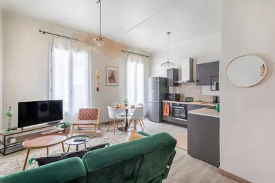 a living room with a green couch and a kitchen at Beautiful 3 bedrooms in a detached house in Aix-en-Provence