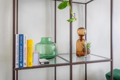 a shelf with a glass bottle and books at Beautiful 3 bedrooms in a detached house in Aix-en-Provence