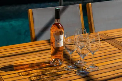 a bottle of wine sitting on a table with three wine glasses at L'Echappée aixoise in Aix-en-Provence
