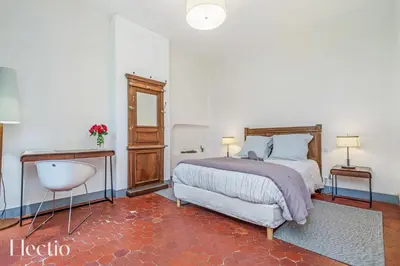 a bedroom with a bed and a table and a sink at Parenthèse en Luberon in Rustrel