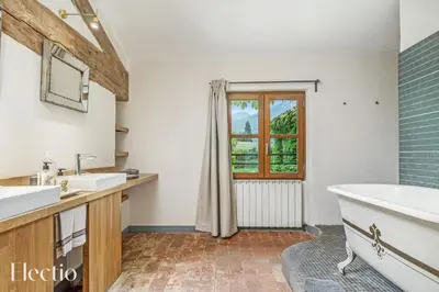 a bathroom with two sinks and a tub and a window at Parenthèse en Luberon in Rustrel