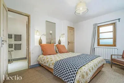 a bedroom with a bed and a window and a chair at Parenthèse en Luberon in Rustrel