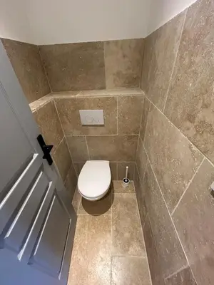 a bathroom with a toilet and a tiled floor at Bastidon provençal entièrement rénové et climatisé in Vaugines