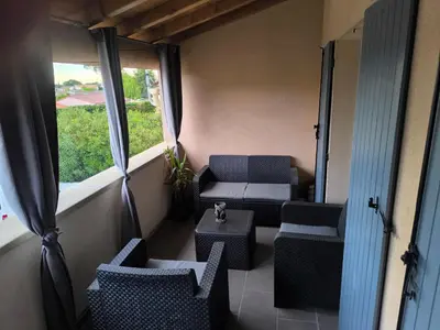 a balcony with chairs and a table and a window at Appartement provençal in Vedène