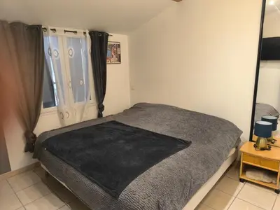 a bedroom with a bed with a black blanket at Appartement provençal in Vedène