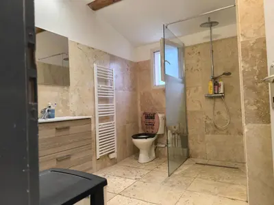 a bathroom with a toilet and a glass shower at Appartement provençal in Vedène