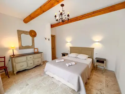 a bedroom with a bed and a dresser and a mirror at Maison de charme 4 étoiles - superbe vue et bassin-piscine privé in Rustrel