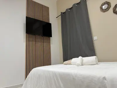 a bedroom with a bed with a flat screen tv at Bonpas Appart Hotels in Avignon