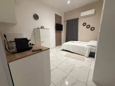 a white room with a bed and a room with a television at Bonpas Appart Hotels in Avignon
