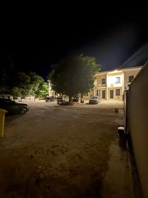 a parking lot in front of a building at night at Bonpas Appart Hotels in Avignon