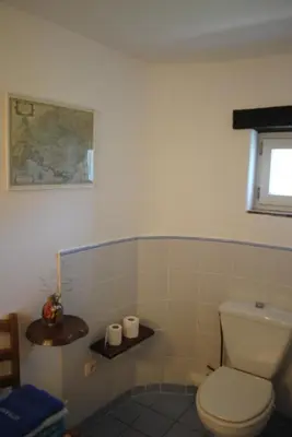 a bathroom with a white toilet and a window at Chambres d'Hôtes Istrane in Rustrel