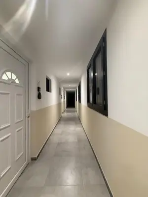 an empty hallway with a white door and a long corridor at Appart hotel bonpas in Noves