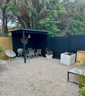a patio with a table and chairs in a blue shed at Maison avec jaccuzzi Aix-en-Provence in Aix-en-Provence