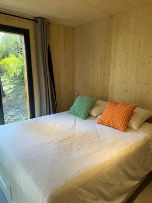 a large bed in a room with a window at Cabane dans le Luberon - Bird in Provence in Cavaillon