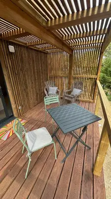 a patio with a table and chairs on a wooden deck at Cabane dans le Luberon - Bird in Provence in Cavaillon