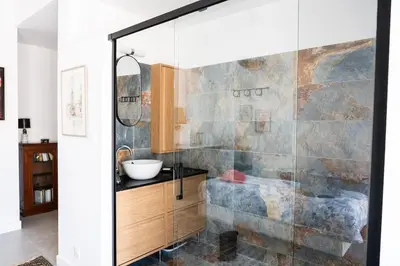 a bathroom with a glass shower with a sink at Maison Familiale Piscine et Proche des commerces in Pertuis