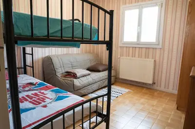a bedroom with a bunk bed and a couch at Maison Familiale Piscine et Proche des commerces in Pertuis