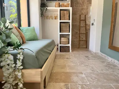 a living room with a couch and a tv at Aix-en-Provence, Cosy studio au calme de la campagne avec Spa et Clim in Aix-en-Provence