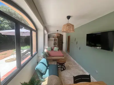 a living room with a couch and a table at Aix-en-Provence, Cosy studio au calme de la campagne avec Spa et Clim in Aix-en-Provence