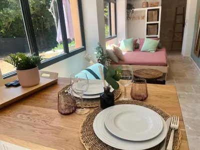 a kitchen and living room with a table and chairs at Aix-en-Provence, Cosy studio au calme de la campagne avec Spa et Clim in Aix-en-Provence