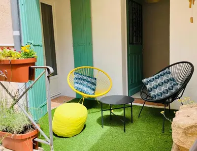 a patio with two chairs and a table and a yellow chair at Cosy studio aix en Provence à 1 minutes du cours Mirabeau in Aix-en-Provence