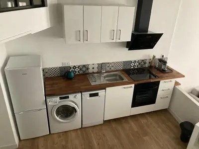 a kitchen with white cabinets and a washer and dryer at Appartement rénové plein centre in Aix-en-Provence