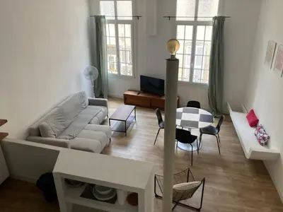 a living room with a couch and a table at Appartement rénové plein centre in Aix-en-Provence
