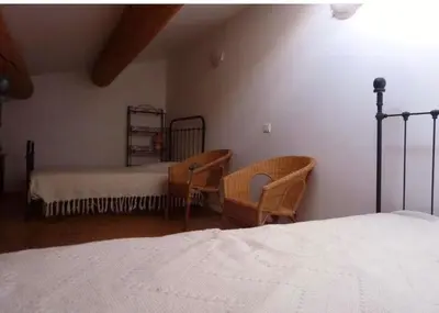 a bedroom with a bed and two chairs at Ferme au pied du luberon in Lourmarin