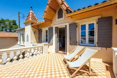 a pair of chairs sitting on a porch of a house at Villa du Val - Welkeys in Aix-en-Provence